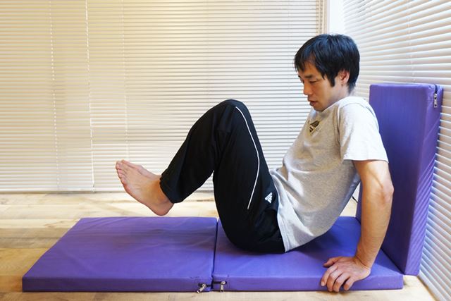 2.両手とお尻で体を支え、足を浮かして膝を胸に引き付ける