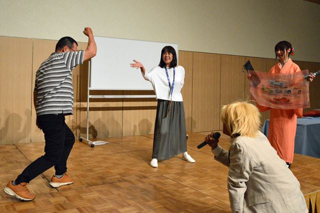 ジャンケン大会を勝ち抜き、手作りの記念品を獲得した舛田さん(写真右)